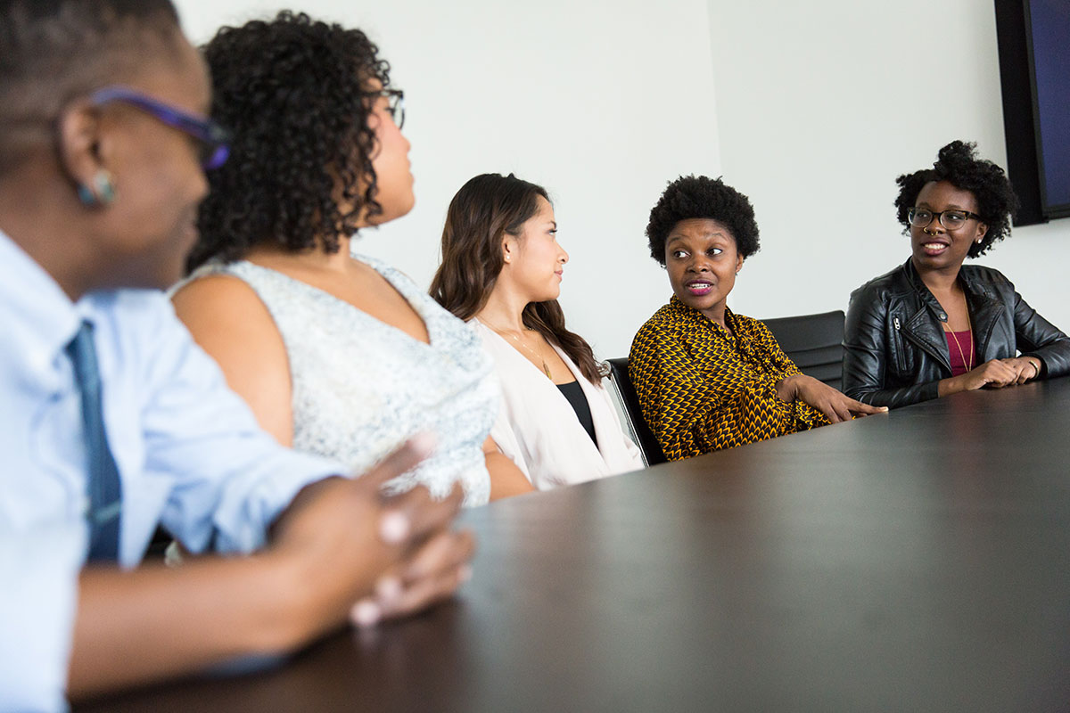 photo of people sitting at a desk talking