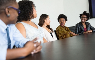 photo of people sitting at a desk talking